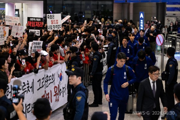 1 ① 제목 2026년 인천국제공항에서 국가대표팀 귀국을 지켜보는 팬들의 복합적인 감정을 사실적으로 표현한 장면.png